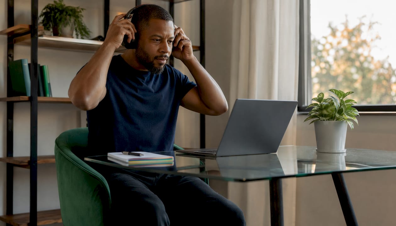Man adjusting headphones for virtual therapy session